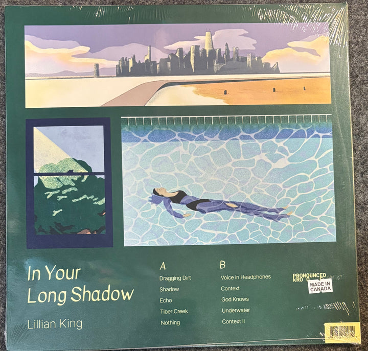 Vinyl record album cover for Lillian King's 'In Your Long Shadow' on a dark green background, featuring an illustrated beach and pool scene. The record is sealed in plastic shrink wrap and photographed on a dark textured surface.
