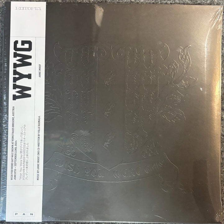 A square vinyl record sleeve for Anne Imhof - WYWG, featuring a metallic bronze embossed crest on a dark background with a white vertical label on the left.