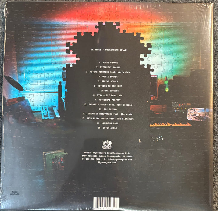The back cover of a vinyl record sleeve for Evidence – Unlearning Vol. 2, featuring a large jigsaw puzzle silhouette over a colorful, pixelated background with tracklist text in the center.