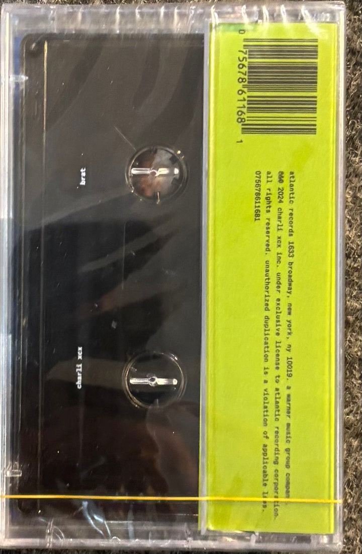 CHARLIE XCX - BRAT tape with a yellow label on a textured surface