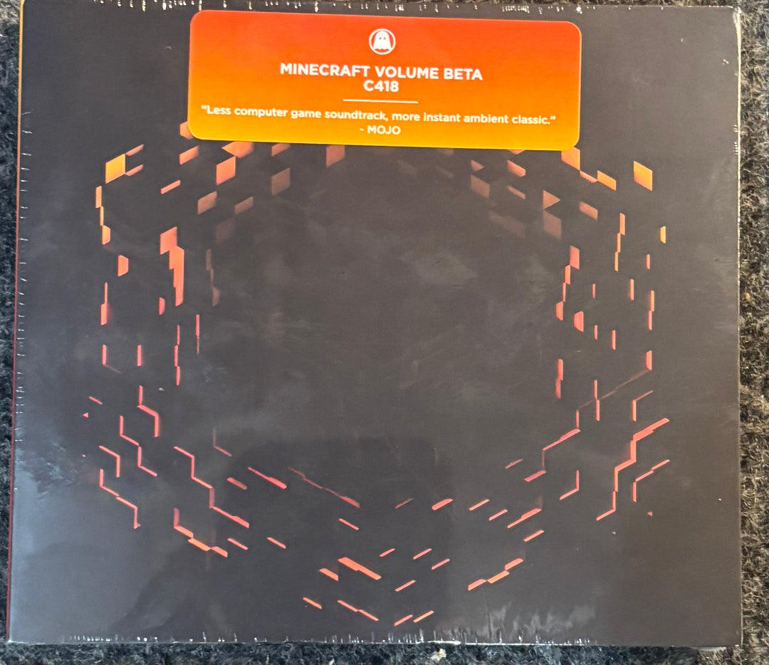 C418 - Minecraft Volume Beta, featuring a black background with a red-orange geometric pattern and a bright orange sticker at the top.