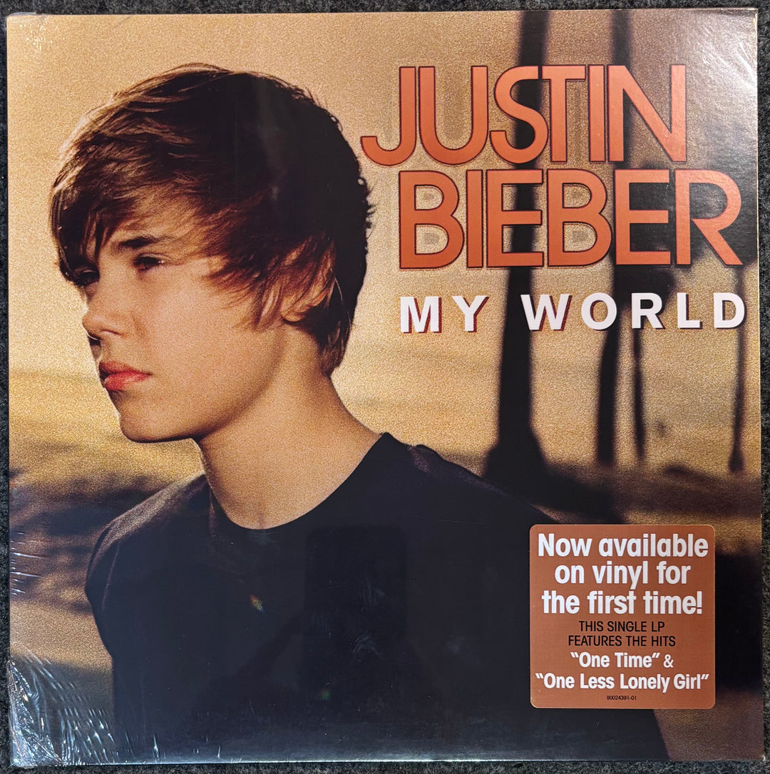 Album cover for Justin Bieber's 'My World' with a portrait of the artist and promotional text.