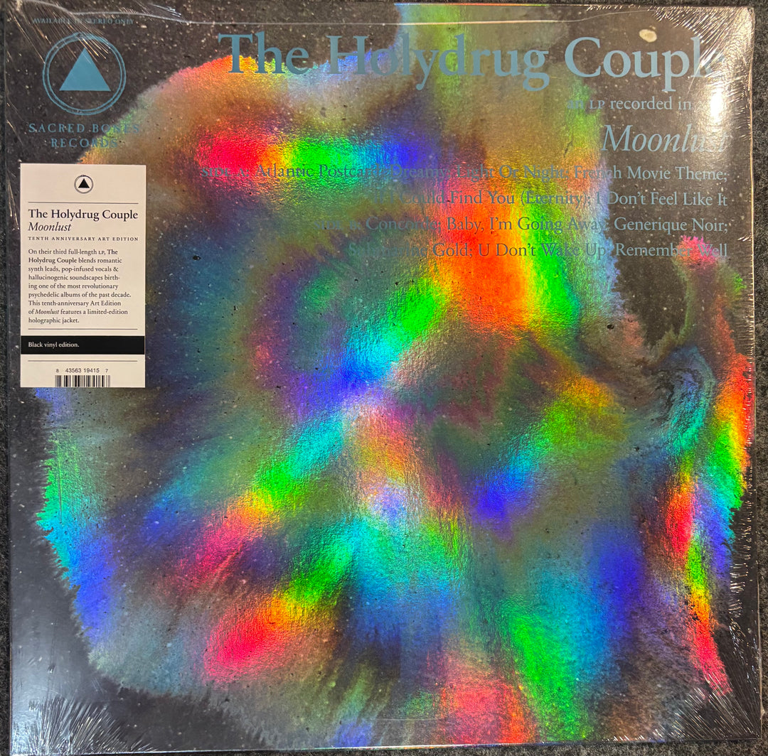 Vinyl record sleeve for 'The Holydrug Couple' , featuring a large, highly reflective holographic rainbow design over a dark background. The left side includes a white paper insert with tracklist details and barcode.