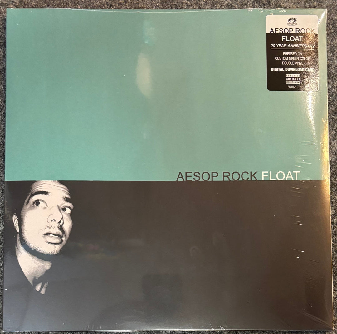 A vinyl record sleeve for Aesop Rock - Float 20 Year Anniversary edition, sealed in plastic. The cover features a split design with a light teal top half and a black-and-white portrait of the artist on the bottom half.
