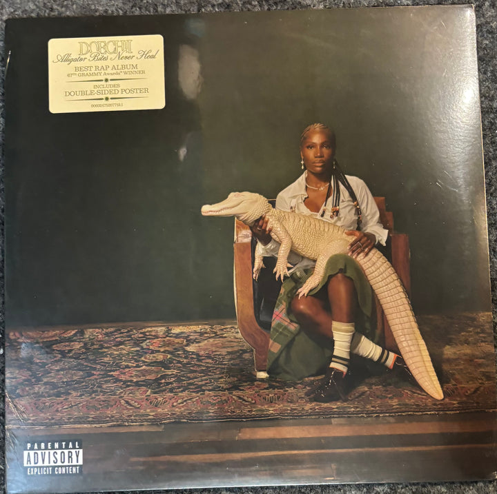 Doechii - Alligator Bites Never Heal record cover with a person holding a crocodile, featuring a 'Parental Advisory' label.