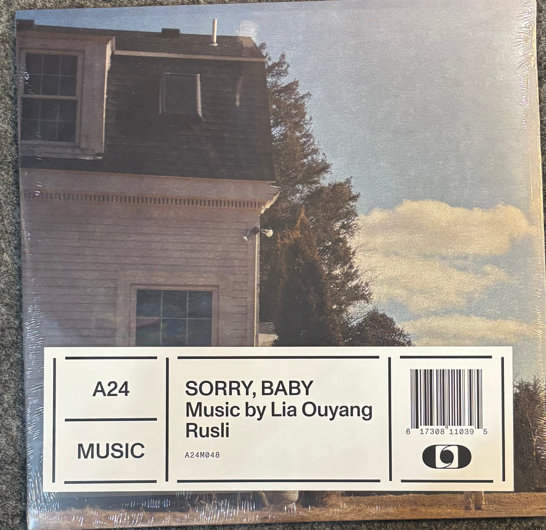 Vinyl record album cover for 'Sorry, Baby' by Lia Ouyang Rusli, featuring a photograph of a house and trees with a white label block at the bottom containing track information and a barcode.