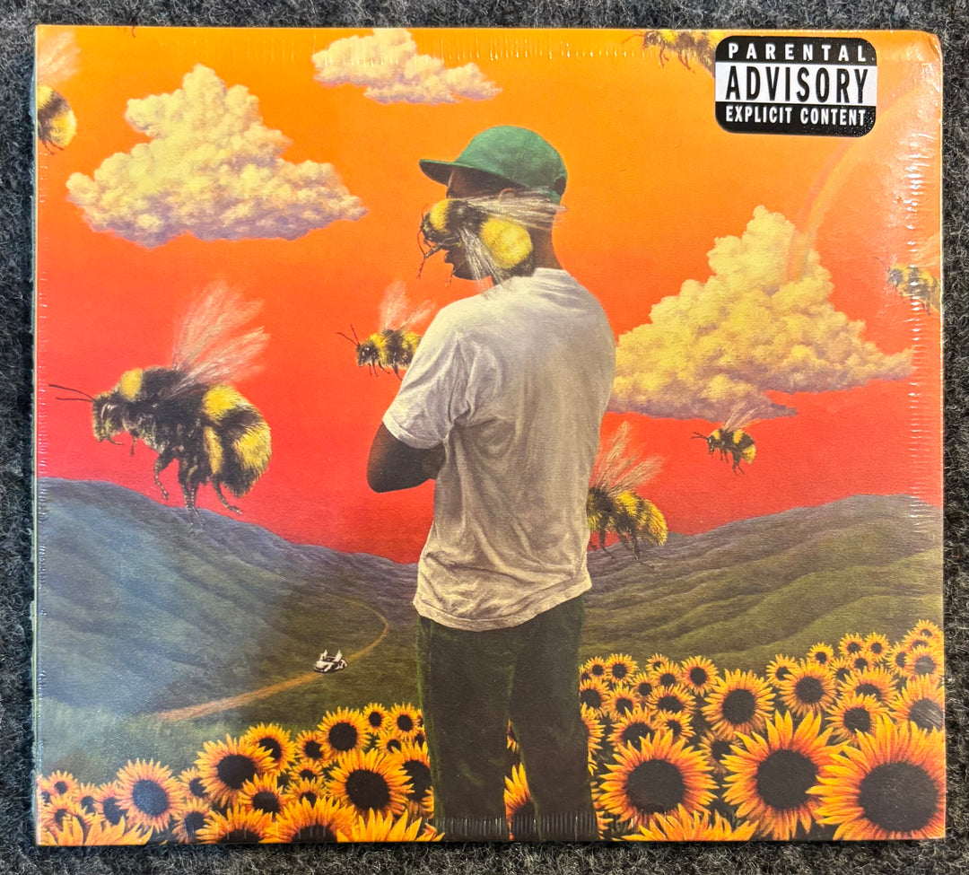 TYLER, THE CREATOR – FLOWER BOY cd cover with a person, bees, and sunflowers on an orange and red background
