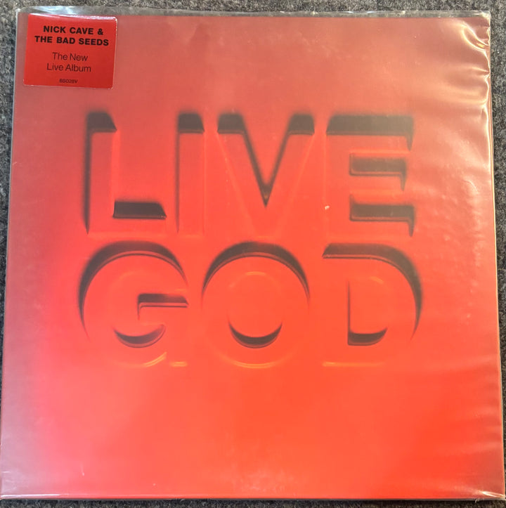 Nick Cave and the Bad Seeds 'The New Live Album' vinyl record cover in its shrink wrap, featuring a bold red-orange gradient background with the album title 'LIVE GOD' in large embossed letters.