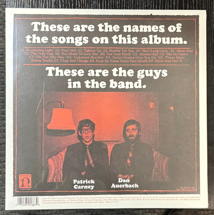 Black Keys - Brothers cover with two individuals sitting on a couch, text about album contents, and a lamp in the background.