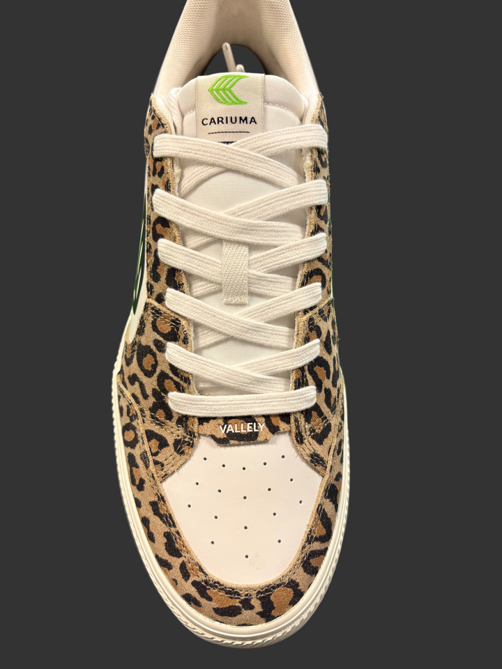 Leopard print sneaker with visible branding on a dark surface with a green box in the background.
