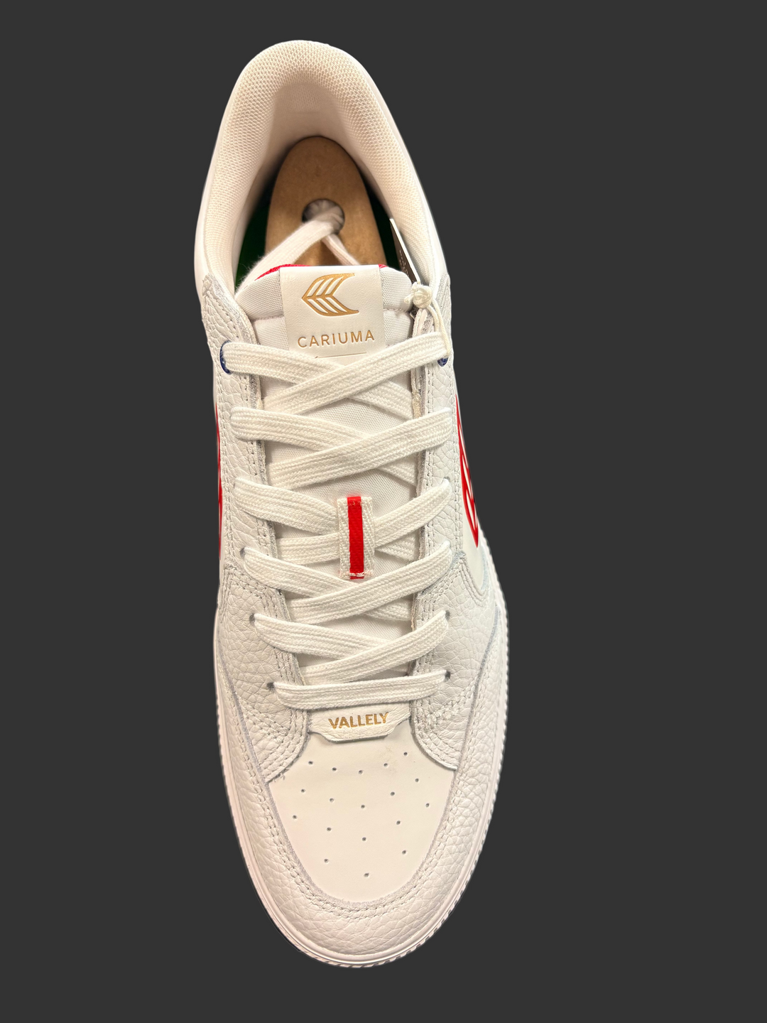 White sneaker with visible branding on a black surface