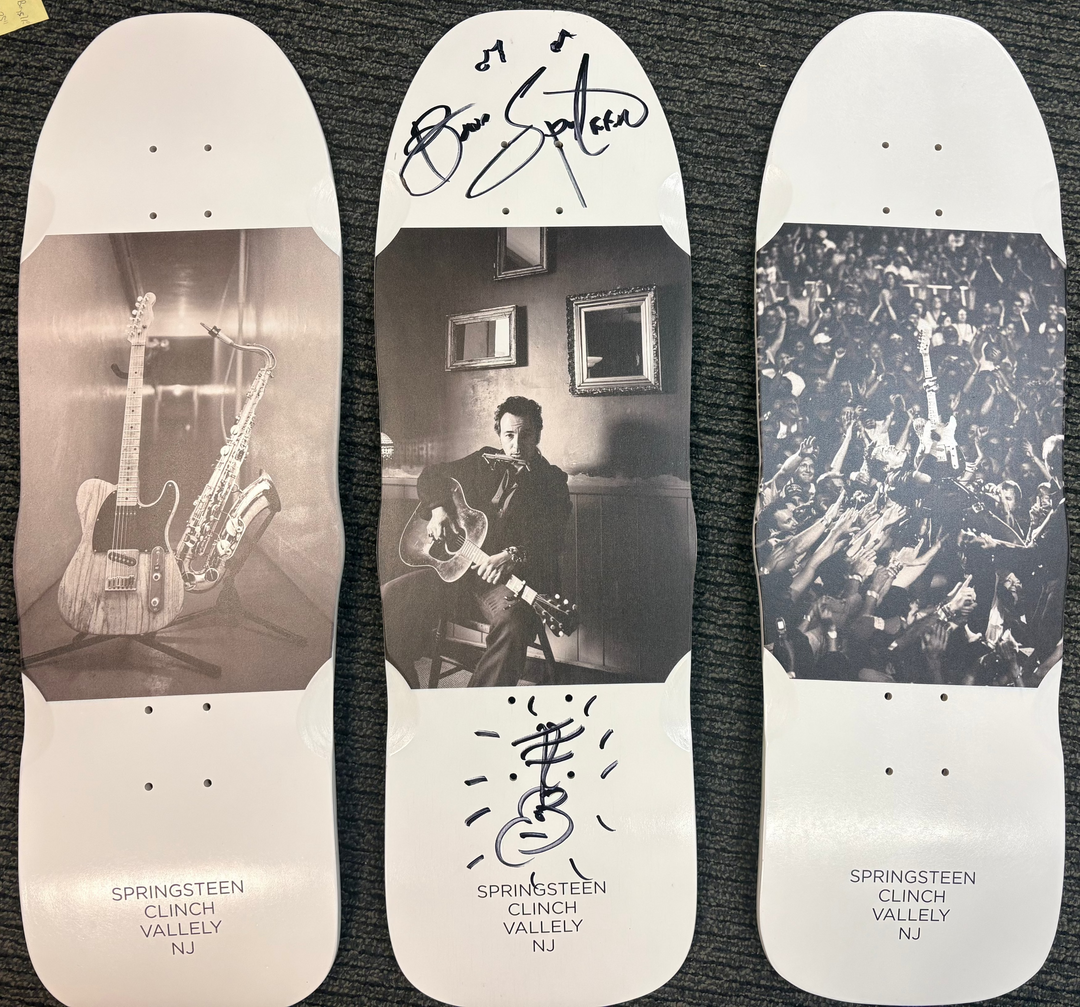 Three skateboard decks with different designs and text on a dark surface