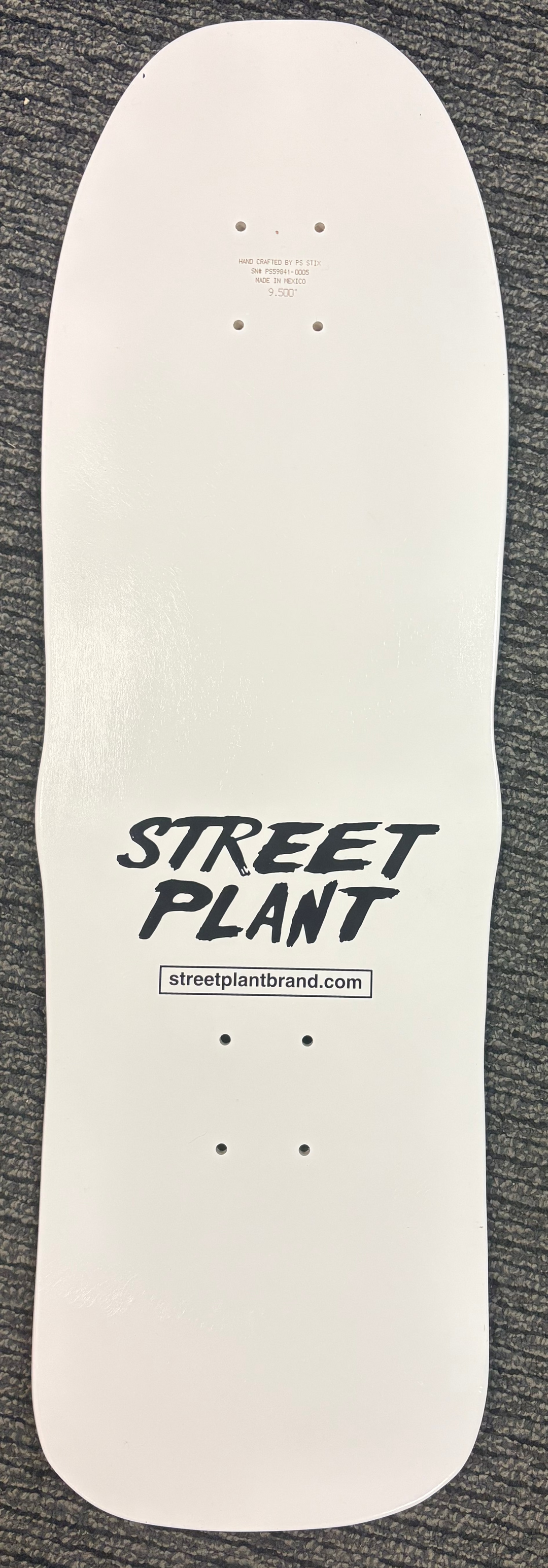 White skateboard deck with 'Street Plant' branding on a gray textured background