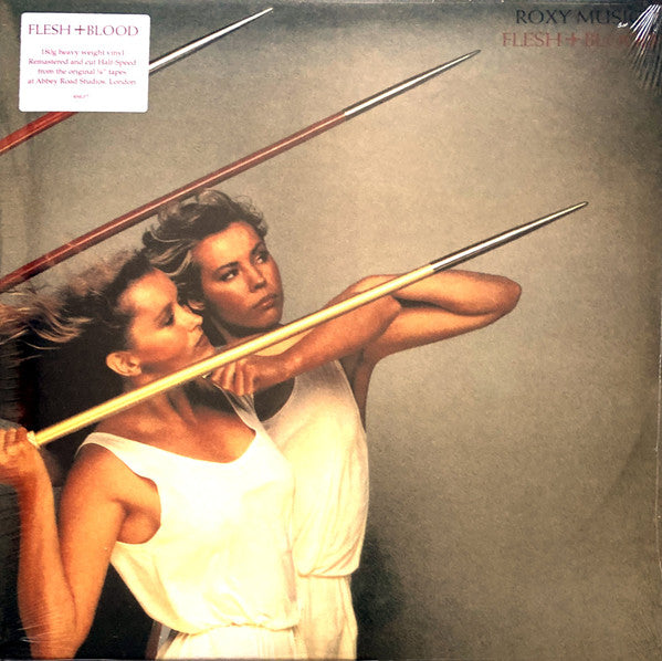 Roxy Music ‎– Flesh And Blood Album cover with two women holding spears, featuring the text 'Flesh + Blood' and 'Roxy Music'.