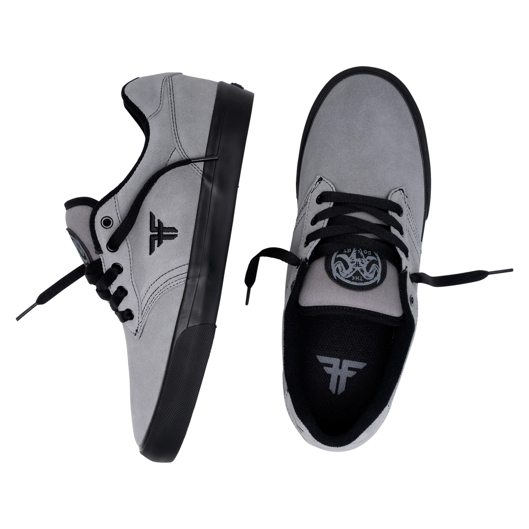 Gray sneakers with black soles and laces on a white background
