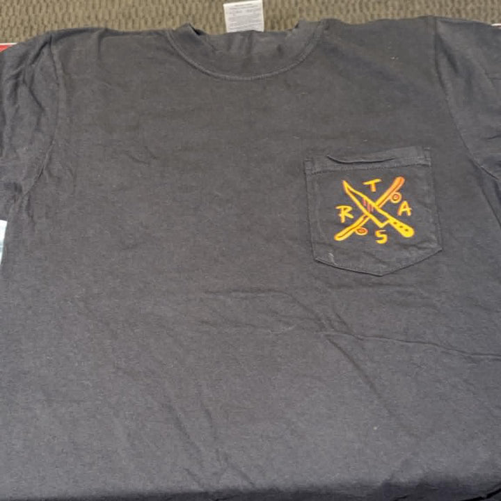 A dark gray pocket t-shirt with a yellow and orange crossed tools graphic on the chest pocket, laid flat on a textured carpet.