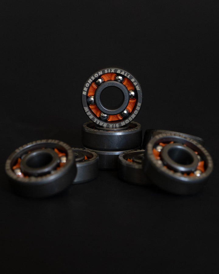 Bronson Six Ball RAW bearings arranged against a black background with their exposed balls visible.