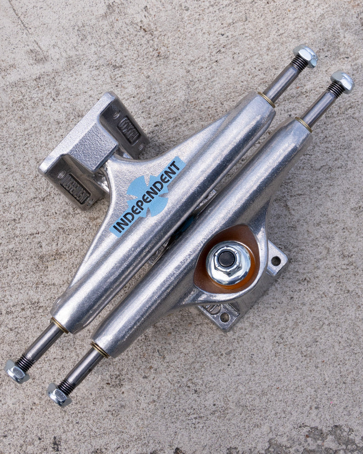 Independent Legacy OGBC Stage 11 trucks on concrete, showing the blue hanger logo and orange bushings.