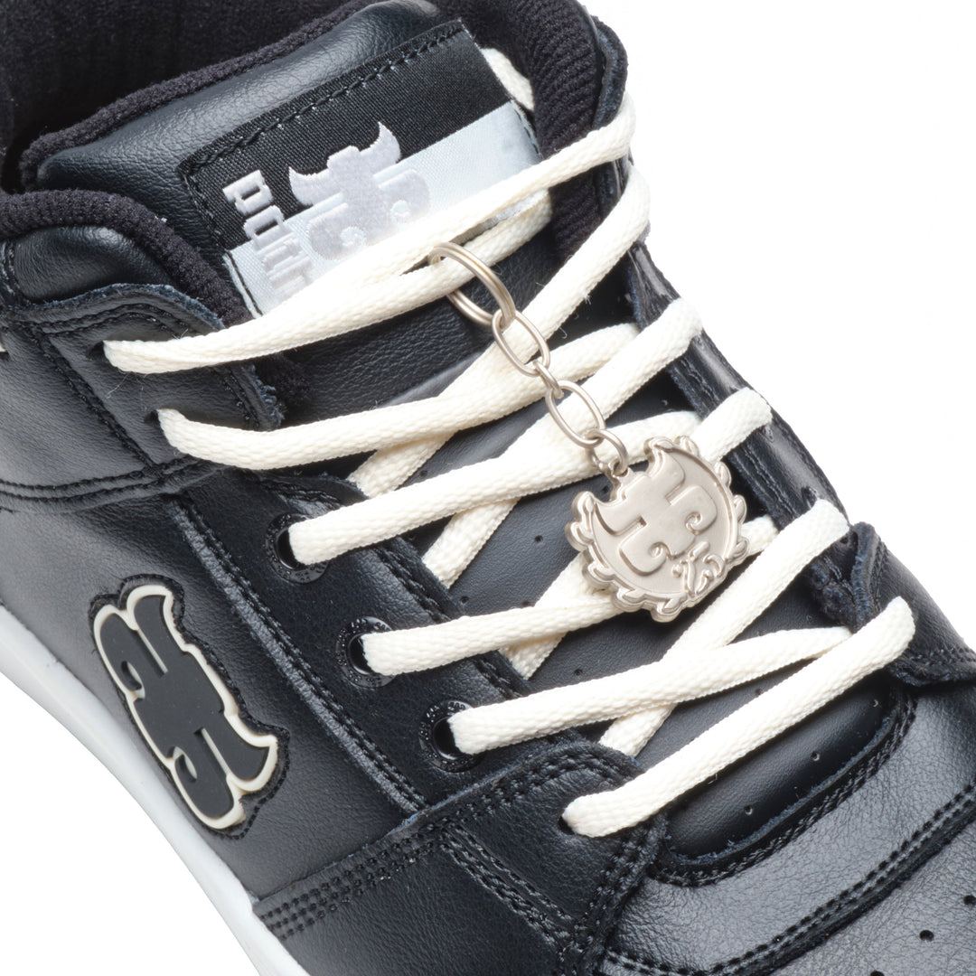 Close-up of the iPath Reed Mid black leather shoe, showing the tongue label, cream laces and metal logo keychain.