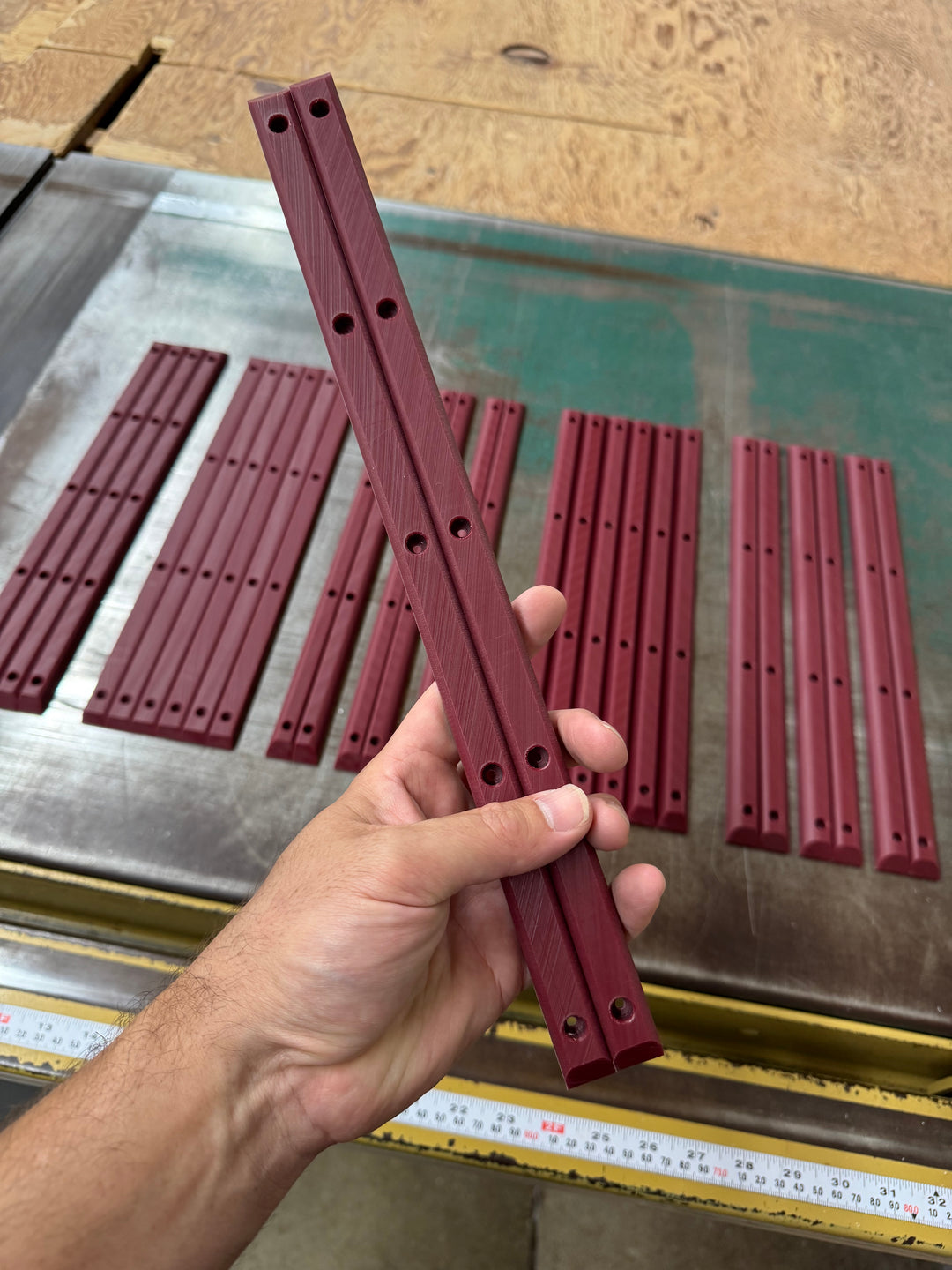 A maroon Lil Jawns Standard rail pair held upright to show the plain tops and five-hole mounting pattern