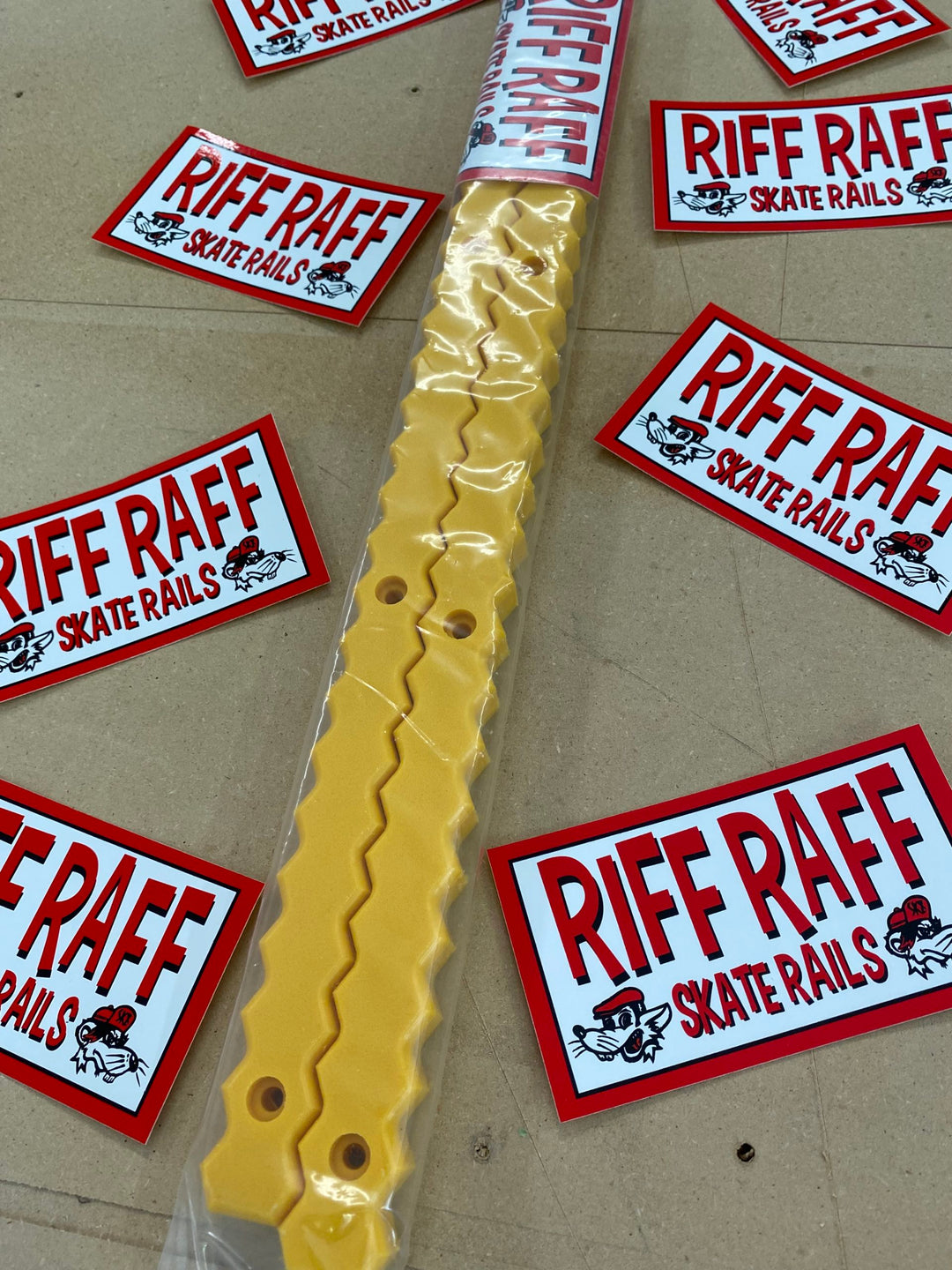 Yellow Riff Raff Zig Zag skateboard rail pair in retail packaging against a Riff Raff sticker backdrop