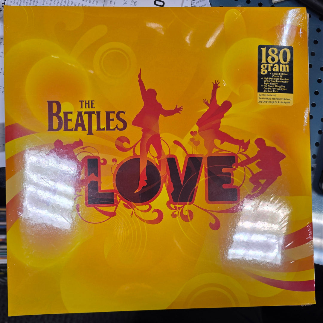Album cover of 'The Beatles Love' on a yellow background