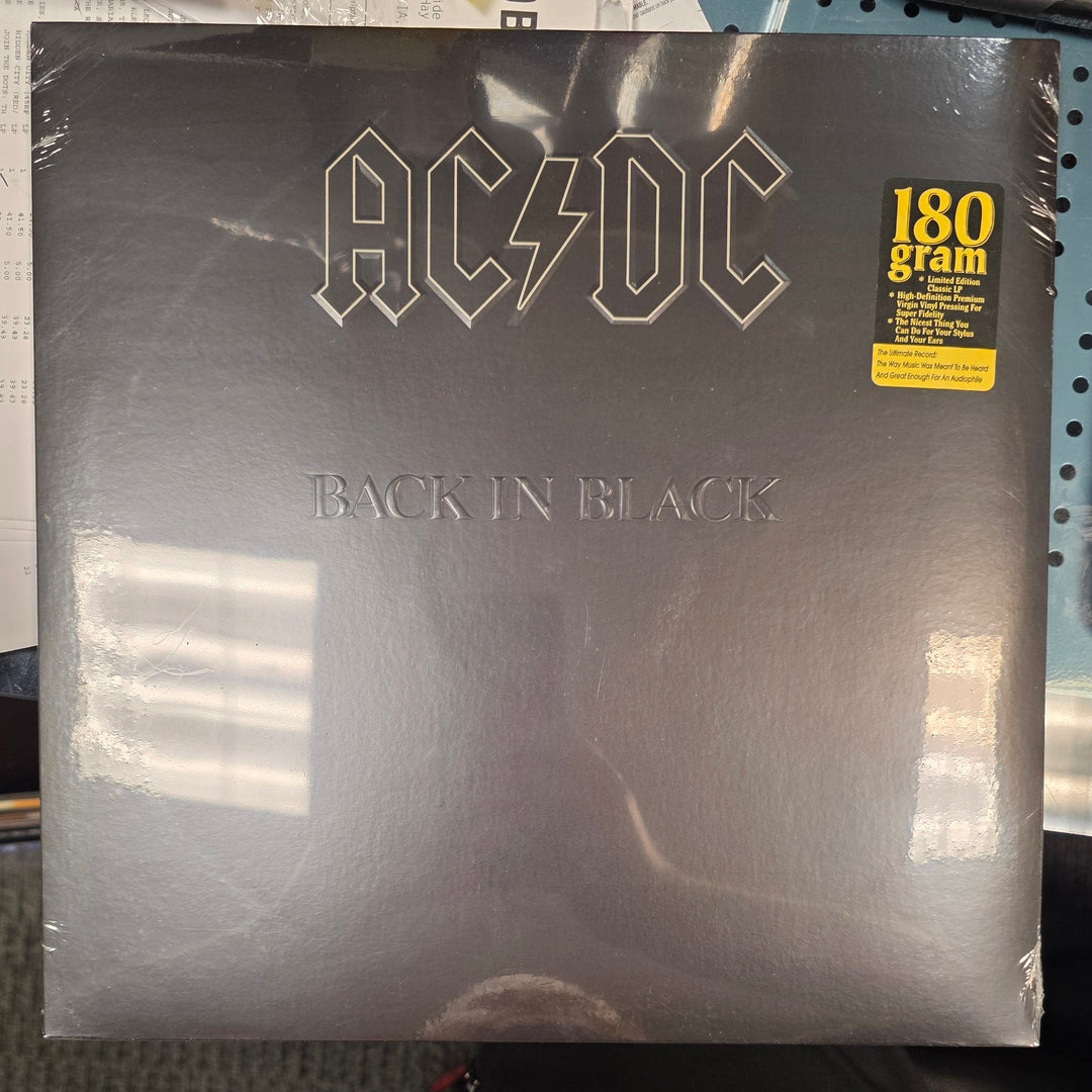 Vinyl record album with 'Back in Black' by AC/DC on a table.