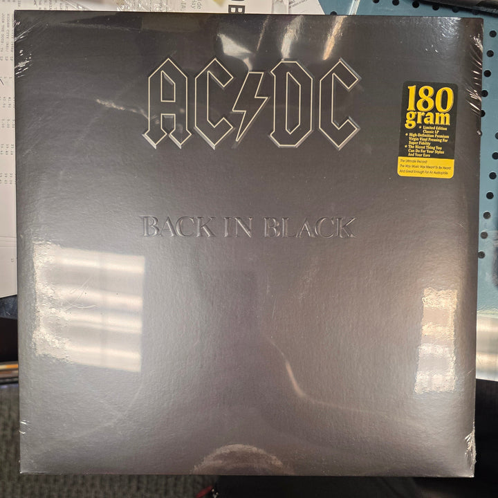 Vinyl record album with 'Back in Black' by AC/DC on a table.