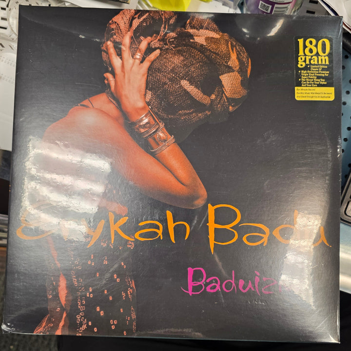 Vinyl record with 'Badu' on a cluttered surface