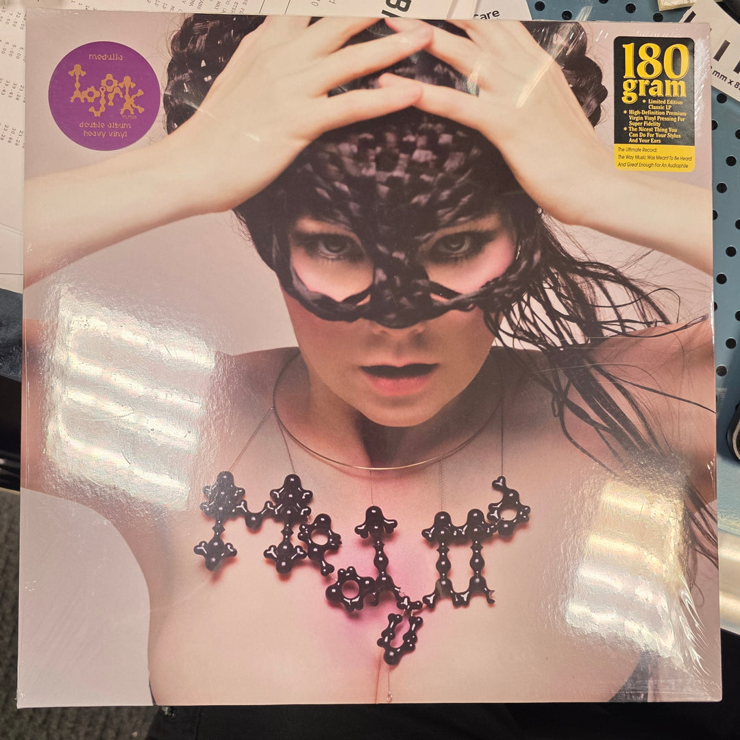 Vinyl record cover with a person wearing a mask on a cluttered surface