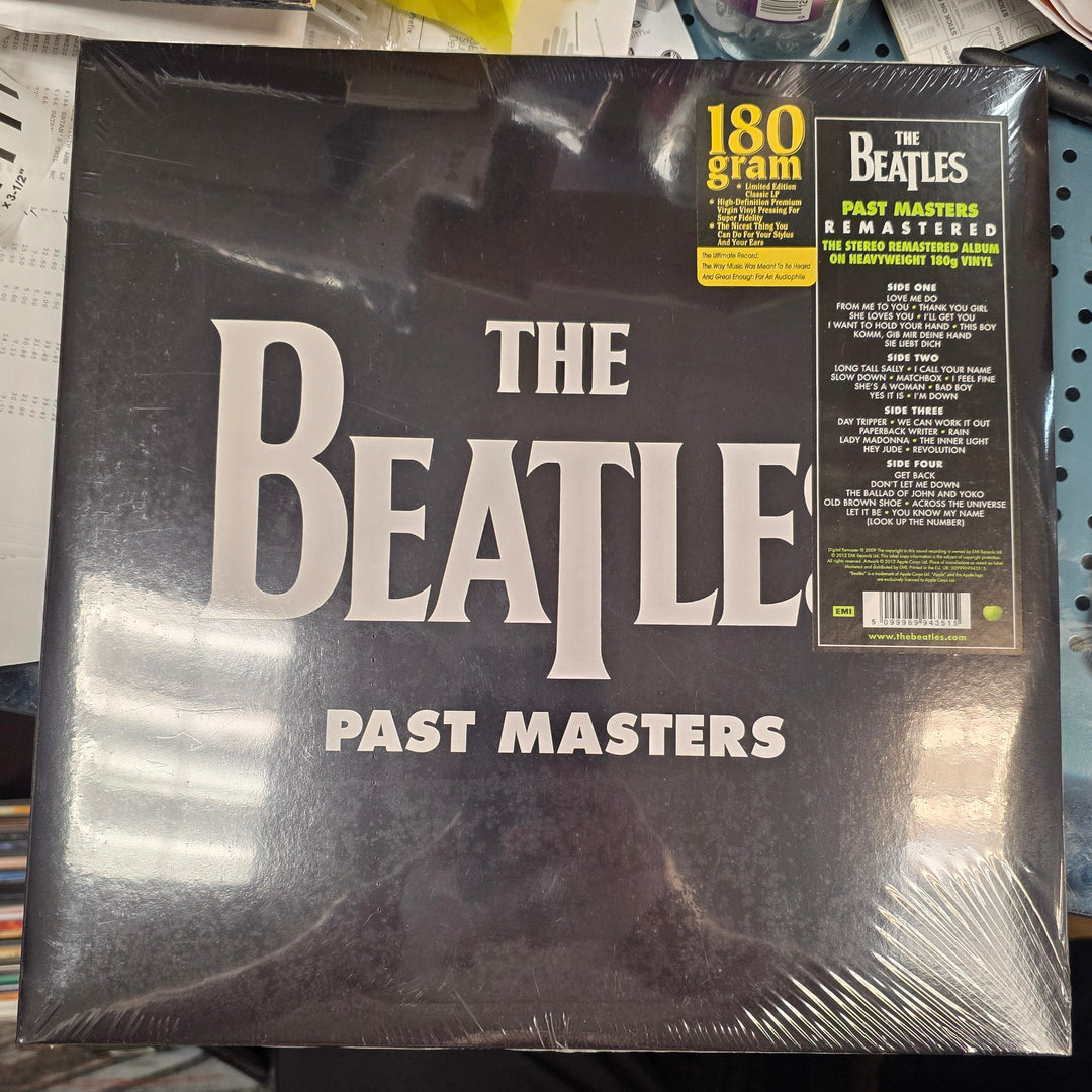 Vinyl record packaging for 'The Beatles Past Masters' on a cluttered surface.