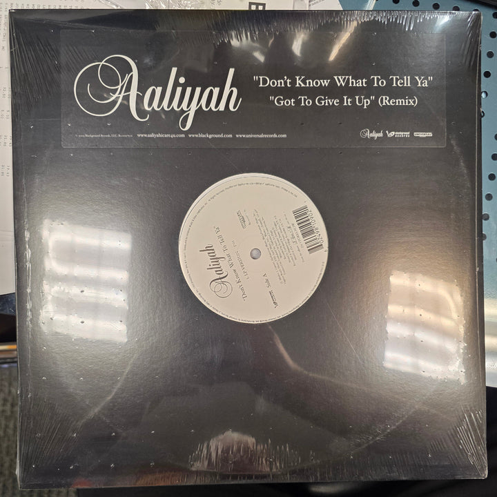 Vinyl record with cover displaying text and a label on a table.