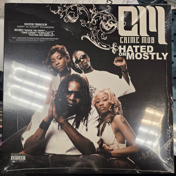 Vinyl record with a cover featuring four people, placed on a surface with scattered items.