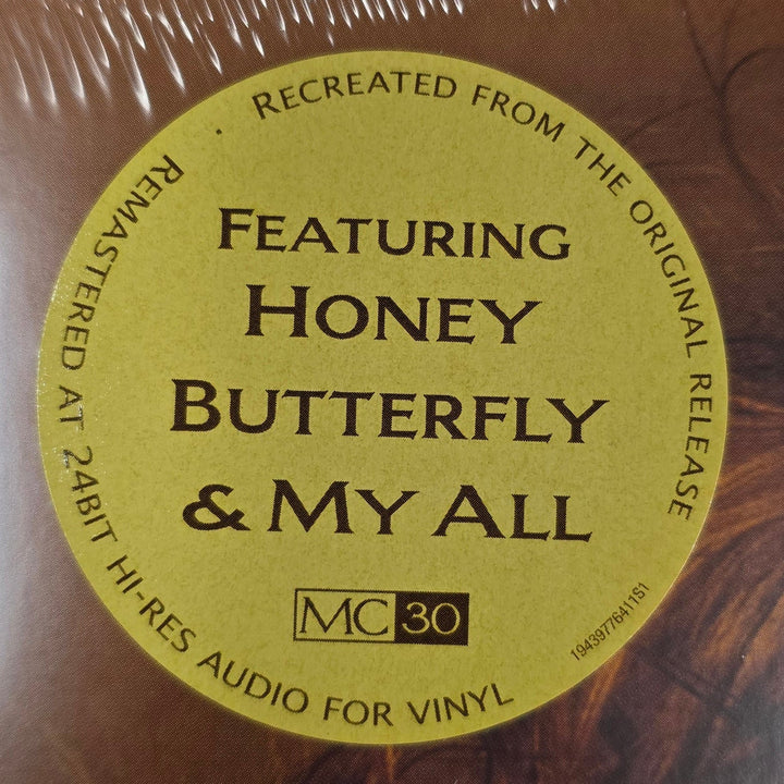 Vinyl record with a label featuring 'Honey Butterfly & My All' on a surface with text and paper.