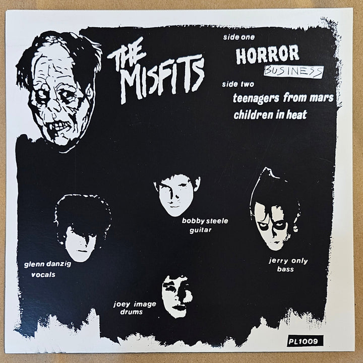 Vinyl 7" record back cover Black and white poster with illustrations of faces and text on a brown surface