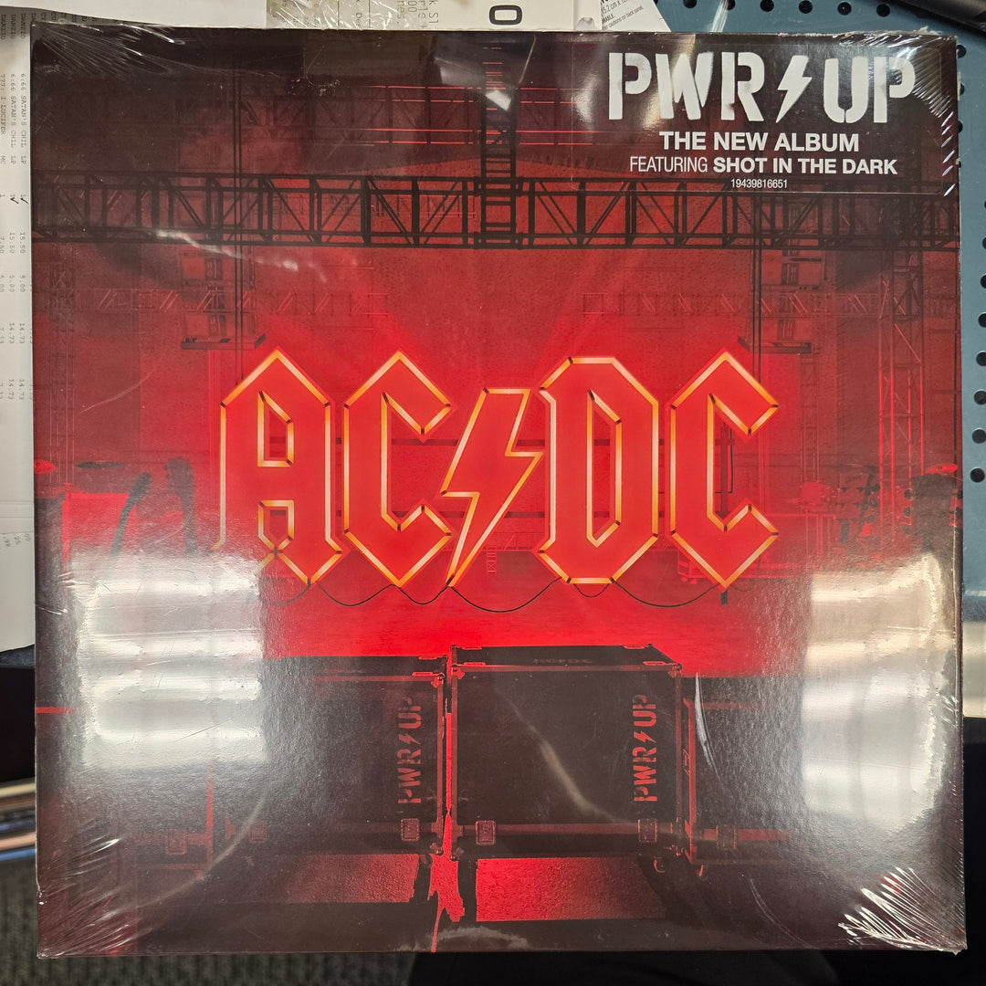 AC/DC album cover with red and black design on a metal surface
