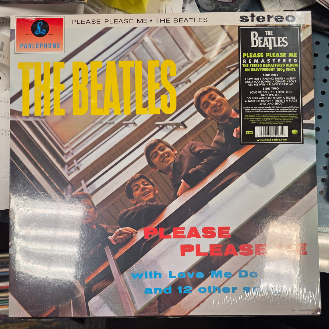 Vinyl record cover of The Beatles' 'Please Please Me' with album design and text.