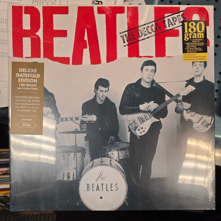 Vinyl record cover with black and white photo of four individuals and red text on a newspaper background